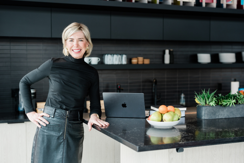A woman leans against a counter. A good example of personal brand photography.