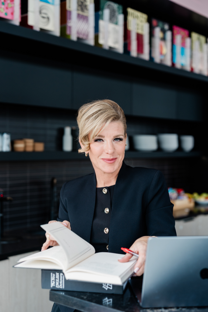 A woman sits at a counter with an open book. A n example of a lifestyle shot for a small business.